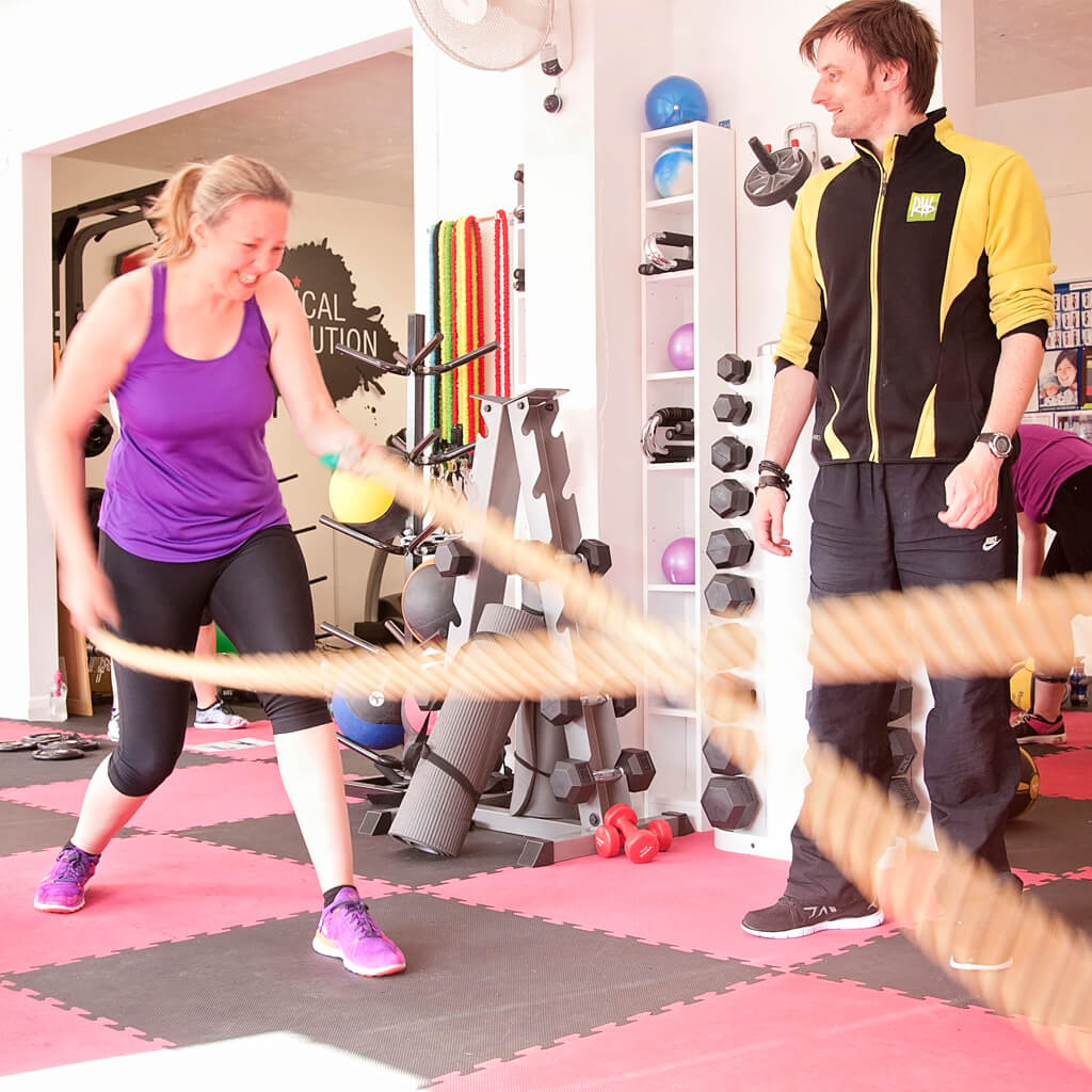 Anthony Punshon coaching a client using battle ropes in his early studio years